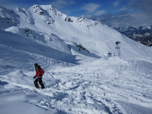 Off-piste above Meribel (Andy standing on skis, in front of mountains)