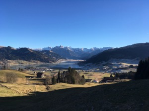 View over Sihlsee, framed by snow covered mountains.