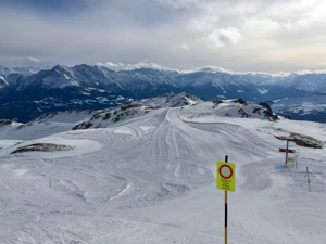 View over grey pistes with low cloud base.