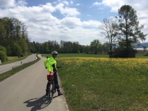 Jules in a bright yellow cycling vest, next to a field