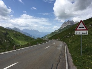 View down the road from the top of Klausen Pass, mountains in the background.