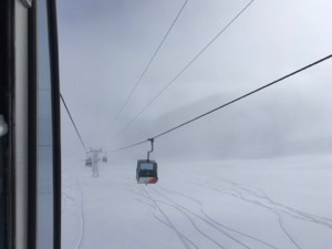 View of foggy ski slope from inside cable car