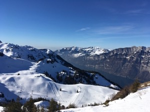 View over snow covered ski pistes with the Walensee in the background