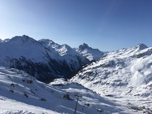 Snow covered mountains of Arlberg under blue skies.