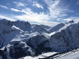 Snow covered mountains of Arlberg under blue skies.