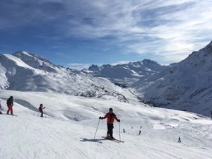 Snow covered mountains of Arlberg under blue skies.