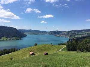 Turquoise waters of the Aegerisee, with green surrounding hills under a blue sky