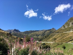 View back up the Oberalppass from the Rhein valley. Mountains under a blue sky.