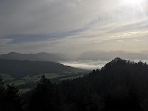 View down into foggy valley, mountains in late afternoon sun