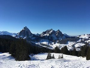 The Grosser and Kleiner Mythens under a blue sky, covered in snow.