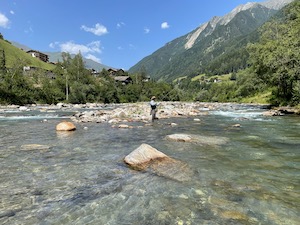 Fisherman standing in the Passeier river, fly-fishing