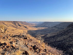 View out from Grootberg lodge. Wide dry river valley, in warm late afternoon sunlight.