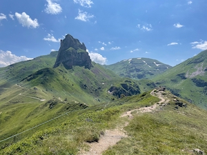 Jagged peaks of Sächsmoor, viewed from the south near Cuncels. Blue skies, rough alpine path in the foreground