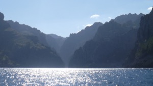 View to rugged coastline almost in silhouette from boat