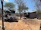 Tambochi campsite, car with tent open, chairs, tables and braai stand nearby. Kitchen area in the back